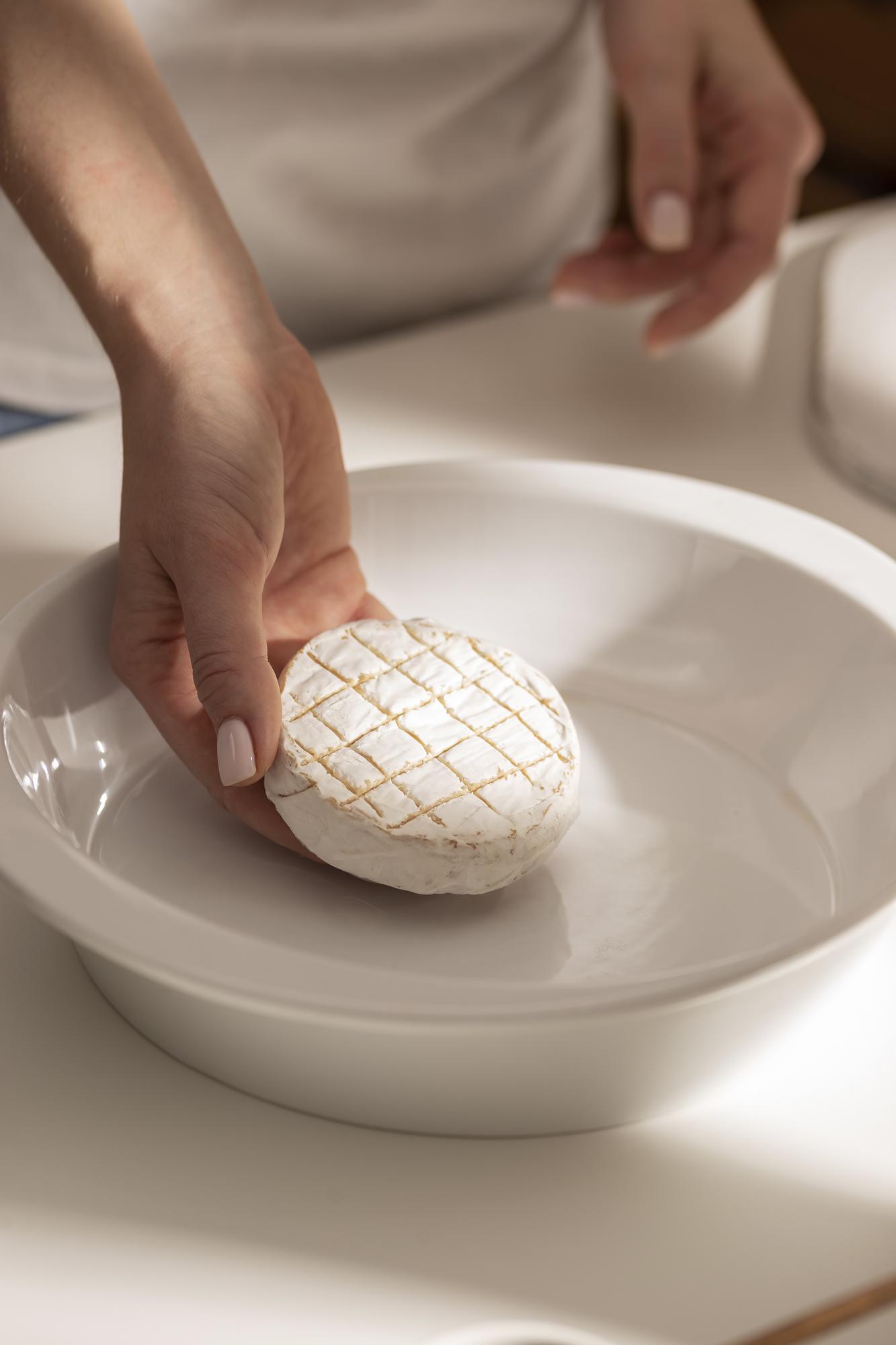 hands plating a simple composed dish on ceramic